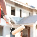 mujer pintando una casa